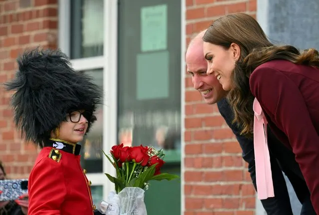 Prince William, Prince of Wales and Catherine, Princess of Wales receive flowers from Henry Dynov-Teixeira, 8, as they depart Greentown Labs, which bills itself as the world’s largest climate technology startup incubator, in Somerville, Massachusetts, on December 1, 2022. (Photo by Angela Weiss/AFP Photo)