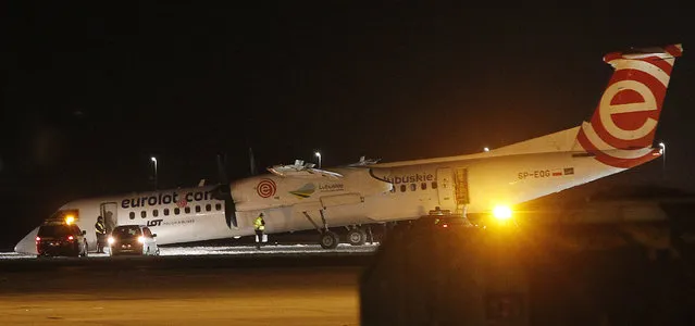 A Polish LOT airline passenger plane rests with its nose down on the runway after making an emergency landing with 59 passengers and four crew aboard, at the international Chopin Airport in Warsaw, Poland, Wednesday, January 10, 2018. Authorities think the front wheel malfunctioned during landing, but nobody was injured in the incident. (Photo by Czarek Sokolowski/AP Photo)