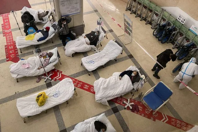 Covid-19 coronavirus patients lie on hospital beds in the lobby of the Chongqing No. 5 People's Hospital in China's southwestern city of Chongqing on December 23, 2022. (Photo by Noel Celis/AFP Photo)