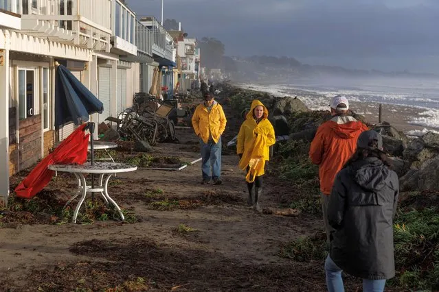 Residents walk along coastal front properties damaged after “atmospheric river” rainstorms slammed northern California, in the town of Aptos, U.S., January 5, 2023. (Photo by Carlos Barria/Reuters)