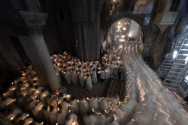 People attend the Holy Thursday mass before the Easter celebrations at the Church of the Holy Sepulchre in the Old City of Jerusalem on March 28, 2024. Participants in the ceremony lit candles and prayed, accompanied by hymns. (Photo by Mostafa Alkharouf/Anadolu via Getty Images)