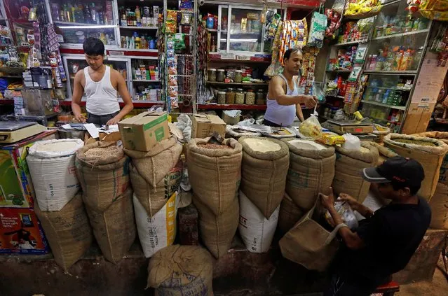 A shopkeeper sells groceries to a customer at his shop in Kolkata, India, September 12, 2016. (Photo by Rupak De Chowdhuri/Reuters)