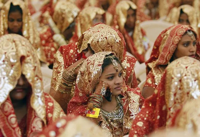 Muslim brides sit as they wait for their weddings to start during a mass marriage ceremony in the western Indian city of Ahmedabad February 22, 2013. A total of 151 Muslim couples from various parts of Ahmedabad took wedding vows during the mass marriage ceremony organised by a Muslim voluntary organisation, organisers said. (Photo by Amit Dave/Reuters)