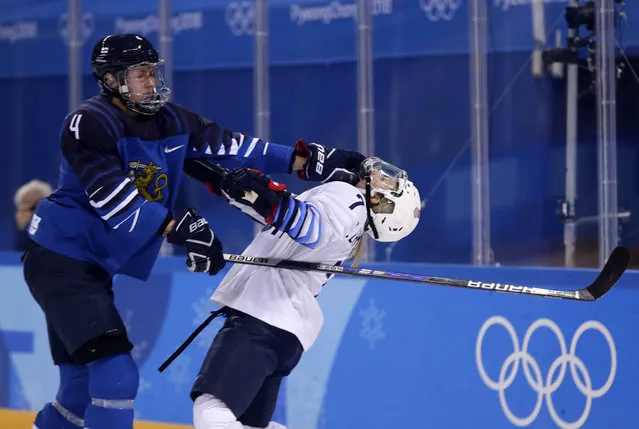 Monique Lamoureux-Morando (7), of the United States, takes a punch from Rosa Lindstedt (4), of Finland, during the second period of the preliminary round of the women's hockey game at the 2018 Winter Olympics in Gangneung, South Korea, Sunday, February 11, 2018. (Photo by Frank Franklin II/AP Photo)