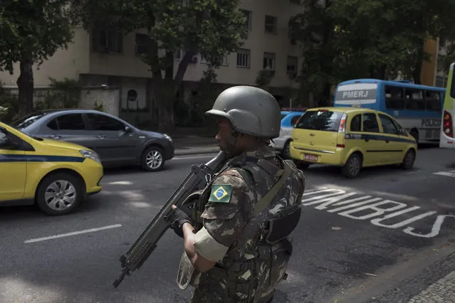 A soldier stands in guard on a street, before a meeting with Brazil's President Michel Temer and local authorities about the implementation of a decree that has placed the military in charge of Rio's state security, at the Guanabara palace in Rio de Janeiro, Brazil, Saturday, February 17, 2018. Temer said he plans to create a public security ministry to coordinate security operations in the entire country. (Photo by Leo Correa/AP Photo)