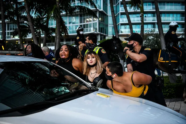 Police arrest supporters of Democratic presidential nominee and former Vice President Joe Biden prior of US President Donald Trump NBC News town hall event at the Perez Art Museum in Miami on October 15, 2020. (Photo by Chandan Khanna/AFP Photo)