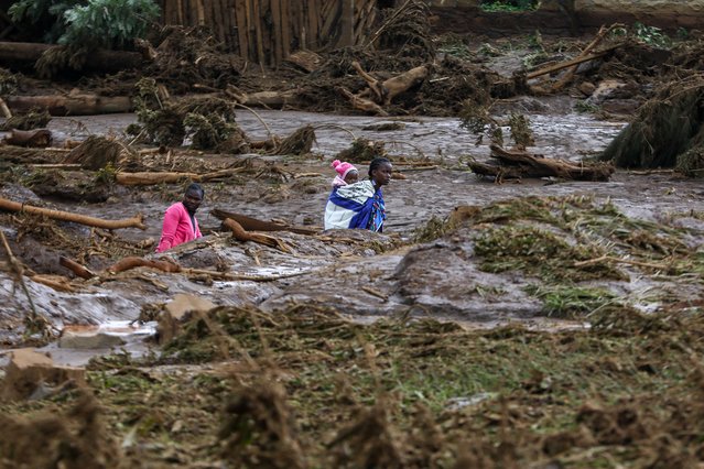 A woman carries a baby as she makes her way in an area affected after Old Kijabe Dam burst its banks and caused flash floods through several villages in Mai Mahiu, in the Rift Valley region of Naivasha, Kenya, 29 April 2024. The flash floods left behind a trail of damaged houses that got swept away, claiming 42 death so far as search and rescue mission continues, according to Kenya Red Cross Society. Kenya and the wider East African region continue to experience flooding due to the ongoing heavy rainfall. (Photo by Daniel Irungu/EPA/EFE/Rex Features/Shutterstock)