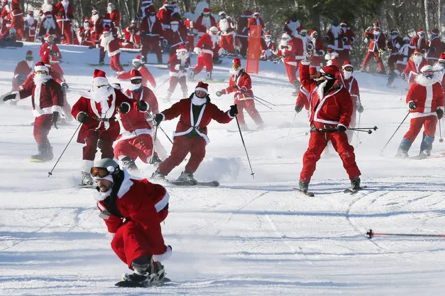 Skiers and snowboarders dressed as Santa participate in a charity run down a slope at Sunday River Ski Resort in Newry, Maine December 7, 2014. (Photo by Brian Snyder/Reuters)