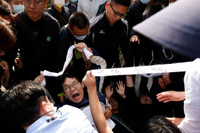 Police take away protesters who stormed in during Taipei Mayor Chiang Wan-an's speech at a ceremony marking the 76th anniversary of a violently suppressed anti-government uprising known as the 228 incident at the 228 Peace Memorial Park in Taipei, Taiwan on Februray 28, 2023. (Photo by Ann Wang/Reuters)