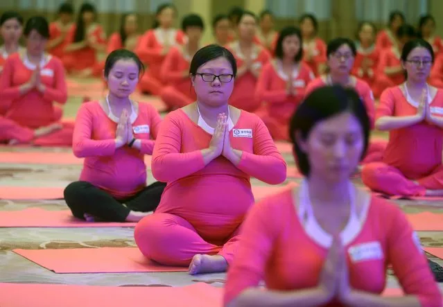 Pregnant women attend a yoga lesson in Beijing during a Guinness record-breaking attempt that was co-hosted in eight Chinese cities October 25, 2015. The event, with a total of 1,443 pregnant women attending across eight cities, created the record for the largest yoga lesson for expectant mothers, local media reported. (Photo by Reuters/Stringer)