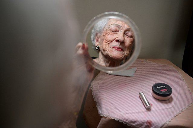 Angela Graterol, 93, looks into a mirror as she gets ready to attend the weekly gathering of Club Tobias at a shopping mall, in Caracas, Venezuela on July 10, 2025. (Photo by Gaby Oraa/Reuters)