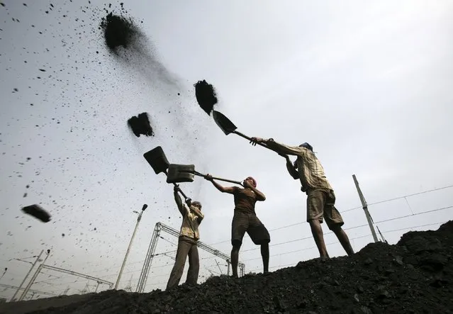 Labourers load coal on trucks at Bari Brahamina on the outskirts of Jammu, India in this March 16, 2012 file photo. (Photo by Mukesh Gupta/Reuters)