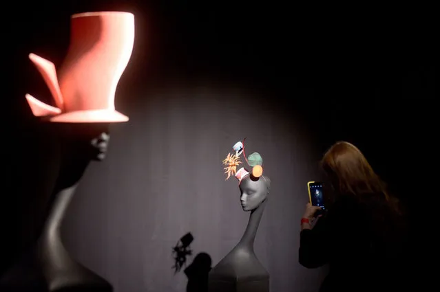 A visitor takes pictures of hats by the famous Irish milliner, fashion designer and world's haute couture expert Philip Treacy during the presentation of the exhibition “Maestro Philip Treacy” displayed at the Erarta museum in Saint Petersburg, on November 18, 2020. (Photo by Olga Maltseva/AFP Photo)