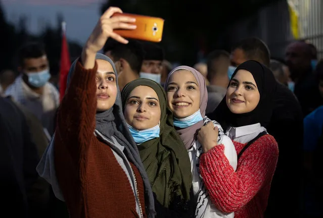 Palestinians girls take a selfie as they participate in a rally to mark the 16th death anniversary of late Palestine Liberation Organization (PLO) leader Yasser Arafat next to his grave in the West Bank town of Ramallah, 11 November 2020. Arafat, who has been the president of the Palestinian Authority from 1994 until his death in 2004, was a founding member and the leader of the Fatah political party from 1959 until 2004. (Photo by Atef Safadi/EPA/EFE)