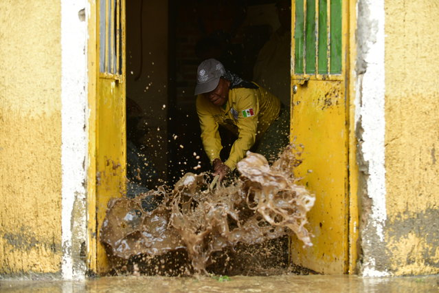 A person removes water from a house during floods caused by the overflowing of the Tagus River in the municipality of Tototlan, Mexico, 29 September 2025. (Photo by Francisco Guasco/EPA)