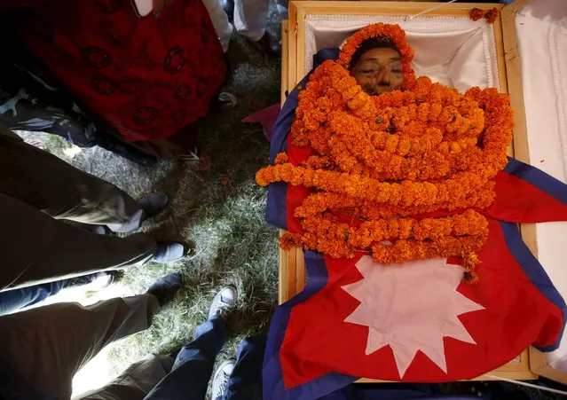 People gather around the body of world's shortest man Chandra Bahadur Dangi during a memorial service organized for the public to pay their condolences to him in Kathmandu, Nepal, October 6, 2015. Dangi, who was 54.6 cm (21.5 inches) inches tall according to Guinness World Records, died on September 3 at the age of 75. (Photo by Navesh Chitrakar/Reuters)