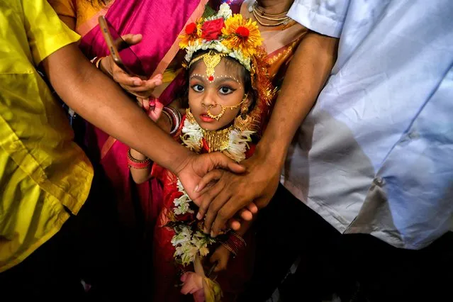 A little girl seen waiting in a queue to participate in the Kumari Puja ritual in Kolkata, India on March 30, 2023. Kumari Puja is an Indian Hindu Tradition mainly celebrated during the Durga Puja / Basanti Puja / Navratri according to Hindu calendar. Kumari actually describes a young virgin girl from the age 1 to 16 who is getting worshipped during the transition of Ashtami / Navami tithi of Durga Puja / Navaratri according to Hindu mythology. Young girls seen being worshipped during the Kumari Puja by their mothers at Adyapith Temple, It is believed that Kumari Puja grant many blessings to the worshipers and as well as the little Girl too. Devotees believe it will overcome all barriers, dangers for the little girls in the coming future and also, she will be empowered to handle any stress and obstruction in her coming life. (Photo by Avishek Das/SOPA Images/Rex Features/Shutterstock)