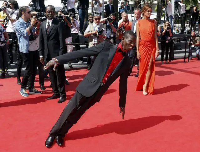 Cast member Souleymane Deme (C) performs on the red carpet as he arrives with director Mahamat-Saleh Haroun (L) and cast member Anais Monory for the screening of the film “Grigris” in competition during the 66th Cannes Film Festival in Cannes May 22, 2013. (Photo by Jean-Paul Pelissier/Reuters)