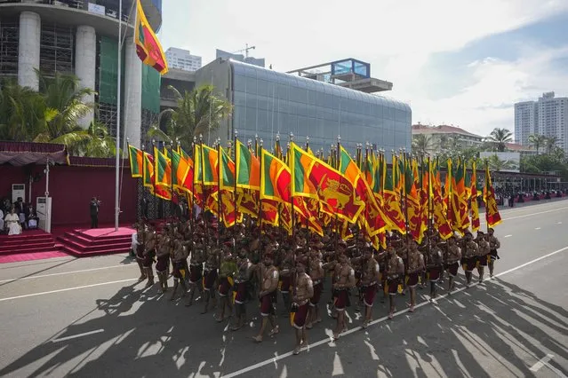Sri Lankan government soldiers march carrying national flags during the 75th Independence Day ceremony in Colombo, Sri Lanka, Saturday, February 4, 2023. (Photo by Eranga Jayawardena/AP Photo)