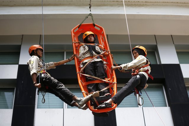 Students and rescue workers simulate the evacuation of a tsunami disaster victim from a high building during an earthquake and tsunami drill in Syiah Kuala University Campus area, Banda Aceh, Indonesia, 21 October 2025. The earthquake and tsunami drill is a part of a disaster mitigation awareness campaign as most of Indonesia's archipelago is known as a disaster prone area as it lies in the Ring of Fire, the most active Tectonic plate in the world. (Photo by Hotli Simanjuntak/EPA)