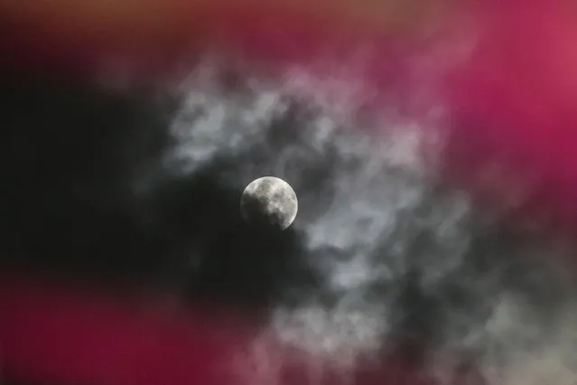 A penumbral lunar eclipse is seen through clouds during the early hours of Saturday in Srinagar, Indian controlled Kashmir, May 6, 2023. (Photo by Mukhtar Khan/AP Photo)