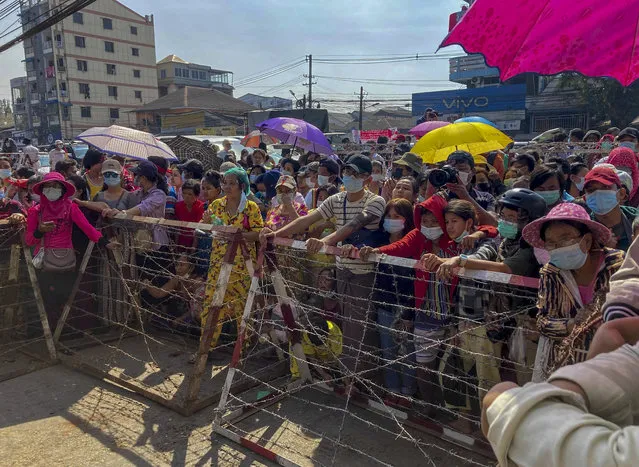 People gather outside Insein prison expecting to see prisoners being released in Yangon, Myanmar Friday, February 12, 2021. Myanmar's military government expected to release thousands of prisoners to mark the anniversary of Myanmar's Union Day. (Photo by AP Photo/Stringer)