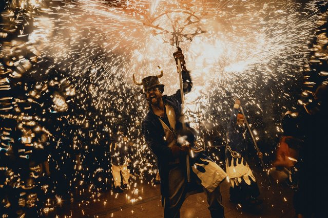 Fire runners dance to traditional drums under fireworks during a “correfoc” in Barcelona's Gracia quarter on October 26, 2024. (Phoot by Matthias Oesterle/Alamy Live News)