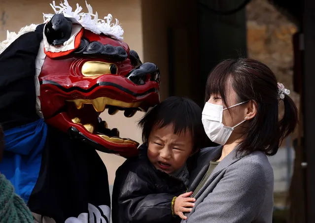 A performer wearing a lion mask performs the Ise Daikagura lion dance at the remote village of Yamanawa on February 08, 2021 in Ryuo, Japan. Ise Daikagura is a group of traditional Lion Dance performers who pray in front of farmers houses and businesses for good grain harvests and disease-free lives. Performers play sacred music using drums and flutes with two lion mask dancers. A lion mask is considered a symbol of God, who enters the house and performs in front of the Shinto God, a statue placed inside the house, mostly in the kitchen. These prayers are called “Kamodo Barai”. After the prayers, they are gifted with money, rice, sake and Japanese sweets from the householders. A group can travel for more than one hundred days to thousands of households and businesses throughout rural-villages in western Japan, and pray to those who are unable to visit the country’s most sacred shrine, the Grand Ise Shrine in Mie Prefecture. The group started its performance in the Edo era between 1603 to 1868 according to Japanese history. The Japanese government designated it as an important folk cultural national property in 1981. (Photo by Buddhika Weerasinghe/Getty Images)
