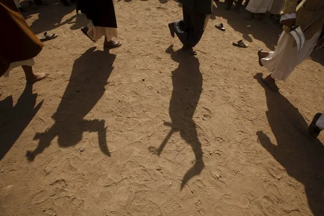 Tribesmen loyal to the Houthi movement cast their shadows on the ground as they perform the traditional Baraa dance during a gathering to show their support for the group, in Yemen's capital Sanaa December 15, 2015. (Photo by Khaled Abdullah/Reuters)