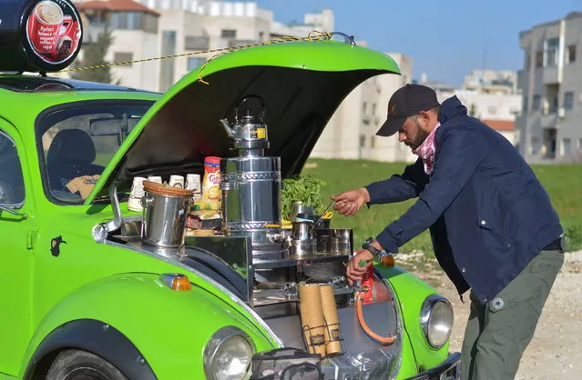 Fadi Ahmad, 33, prepares hot drinks for sale out of his Volkswagen Beetle, in Amman, Jordan February 16, 2021. (Photo by Muath Freij/Reuters)