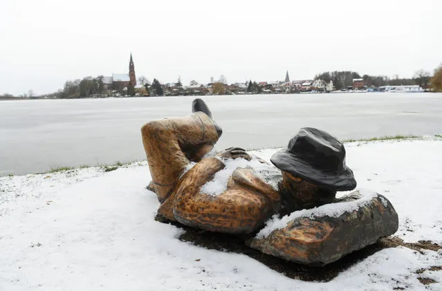 A snow-covered wooden sculpture is seen at the waterfront of lake Mueritz, in Roebel, Germany, February 4, 2021. (Photo by Annegret Hilse/Reuters)