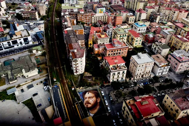 An aerial photo shows a giant portrait of Catalan rapper Pablo Hasel painted on the ground by Italian street artist Jorit in Naples, Italy, 08 March 2021. Pablo Hasel was arrested and sentenced in 2018 over the lyrics of his song and tweets that allegedly glorified terrorism. (Photo by Ciro Fusco/EPA/EFE)