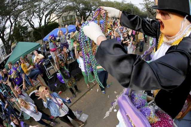 A member of the Krewe of Thoth throws beads during a Mardi Gras parade in New Orleans, Louisiana February 15, 2015. (Photo by Jonathan Bachman/Reuters)