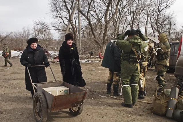 Ukrainian women push a trolley past pro-Russia rebels in Debaltseve, eastern Ukraine on Thursday, February 19, 2015. (Photo by Peter Leonard/AP Photo)