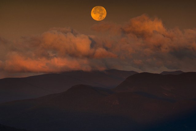 The blue supermoon sets over the White Mountain National Forest at sunrise, Thursday, August 31, 2023, in Carroll County, New Hampshire. The next blue superman won't occur until 2037. (Photo by Robert F. Bukaty/AP Photo)
