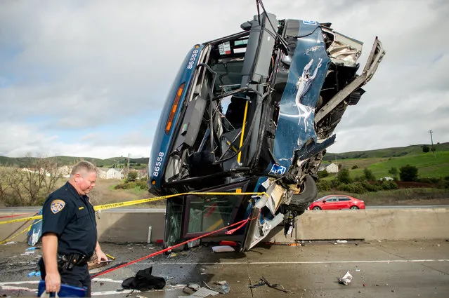A California Highway Patrol officer moves belongings from a Greyhound bus crash that left two dead and at least eight injured on Tuesday, January 19, 2016, in San Jose, Calif. A Greyhound spokeswoman said the bus, which left Los Angeles Monday night, was carrying 20 passengers in addition to the driver. (Photo by Noah Berger/AP Photo)