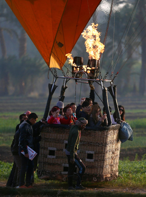 Crew members work to secure a hot-air balloon after landing as tourists cheer, at the city of Luxor, south of Cairo, Egypt December 13, 2016. (Photo by Amr Abdallah Dalsh/Reuters)