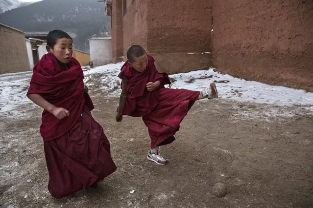 Tibetan Buddhist monks play soccer outside their hostel during Monlam or the Great Prayer rituals on March 4, 2015 at the Labrang Monastery, Xiahe County, Amdo, Tibetan Autonomous Prefecture, Gansu Province, China. (Photo by Kevin Frayer/Getty Images)