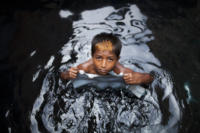 Miraj, 11, seen working at a tannery without any safety equipment on August 18, 2015 in Dhaka, Bangladesh. Dhaka's Hazaribagh area, widely known for its tannery industry, produces 15 million sq. ft. of leather every year. Listed as one of the 10 most polluted places on earth, the area houses 270 registered tanneries with about 20,000 people working there. (Photo by Zakir Hossain Chowdhury/Barcroft Media)