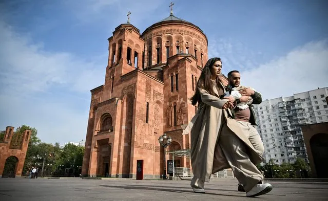 Ethnic Armenians walk past the Armenian Cathedral of Moscow, officially known as Holy Transfiguration Cathedral, the tallest Armenian church in the world and the largest one outside Armenia, on October 4, 2023. Armenian lawmakers approved a key step towards joining the International Criminal Court (ICC), a move that was expected to escalate tensions with the ex-Soviet country's traditional ally Moscow. Tensions have also been rising between Yerevan and Moscow over the role of Russian peacekeepers in the self-proclaimed republic of Nagorno-Karabakh, which announced its dissolution last week following the lightning military operation by Baku. (Photo by Alexander Nemenov/AFP Photo)