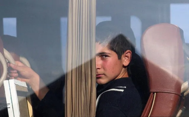 A refugee from Nagorno-Karabakh region looks out of a bus upon at a checkpoint in the village of Kornidzor, Armenia on September 24, 2023. (Photo by Irakli Gedenidze/Reuters)