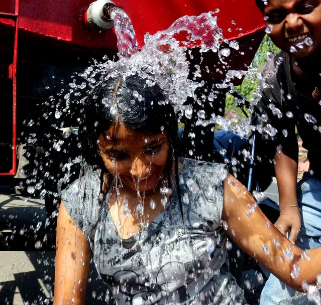 A girl takes a bath from a public water tank on the occasion of World Water Day in Bhopal, India, March 22, 2015. (Photo by Sanjeev Gupta/EPA)