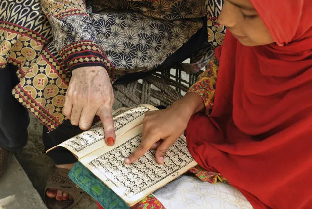 In this Tuesday, June 26, 2018, photo, Ansa Khan first's work in the morning after breakfast is to recite the Quran with her religious teacher in her village in Mardan, Pakistan. After that her day is a whirl of chores, school, studying and the occasional moments stolen away to play marbles. (Photo by Saba Rehman/AP Photo)