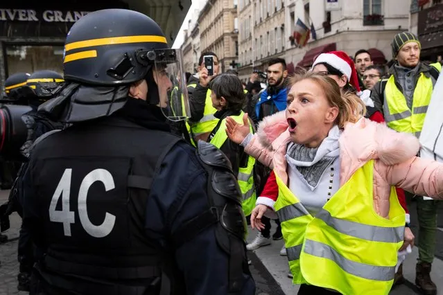 A protester shouts at the French riot police during a “Yellow Vests” protest near La Madeleine in Paris, France, 22 December 2018. The so-called “gilets jaunes” (yellow vests) is a protest movement, which reportedly has no political affiliation, that continues protests across the nation over high fuel prices. (Photo by Etienne Laurent/EPA/EFE)
