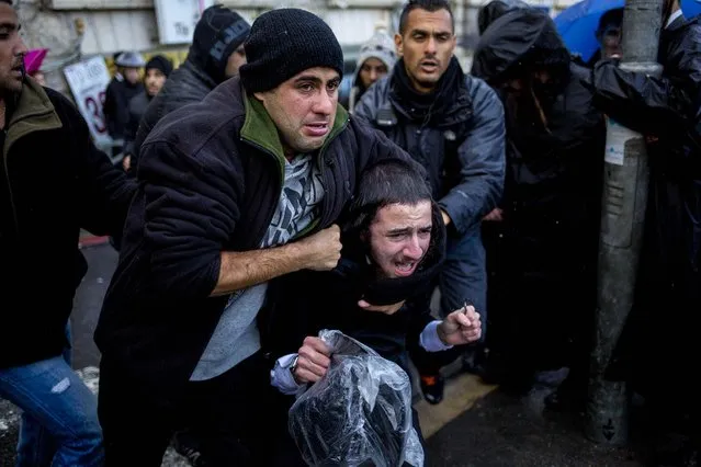 A plain clothes policeman detains an ultra-Orthodox Jew during a protest against military service in Jerusalem, on December 5, 2013. Ultra-Orthodox have traditionally received exemptions from compulsory military service and have battled attempts to force them to serve. (Photo by Dusan Vranic/Associated Press)