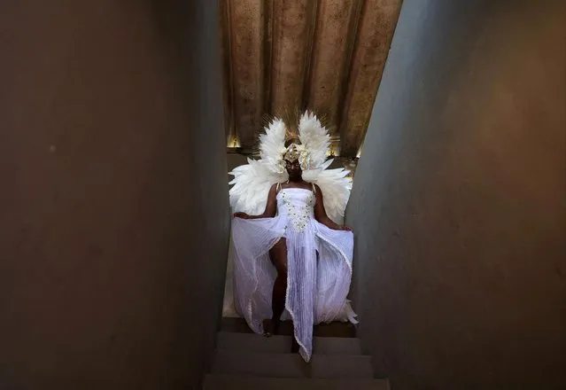 Viviane Oliveira wears a white costume as she represents an angel, before a Christmas celebration organized by the NGO Favela Mundo, with the participation of Black actors, for giving importance to diversity and inclusion, in the Caju slums complex in Rio de Janeiro, Brazil on December 14, 2023. (Photo by Pilar Olivares/Reuters)