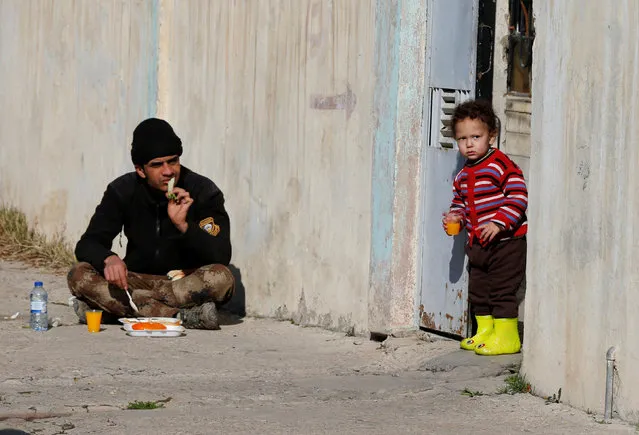 A member of Iraqi Special Operations Forces (ISOF) eats food during an operation to clear the al-Andalus district of Islamic State militants, in Mosul, Iraq, January 16, 2017. (Photo by Muhammad Hamed/Reuters)