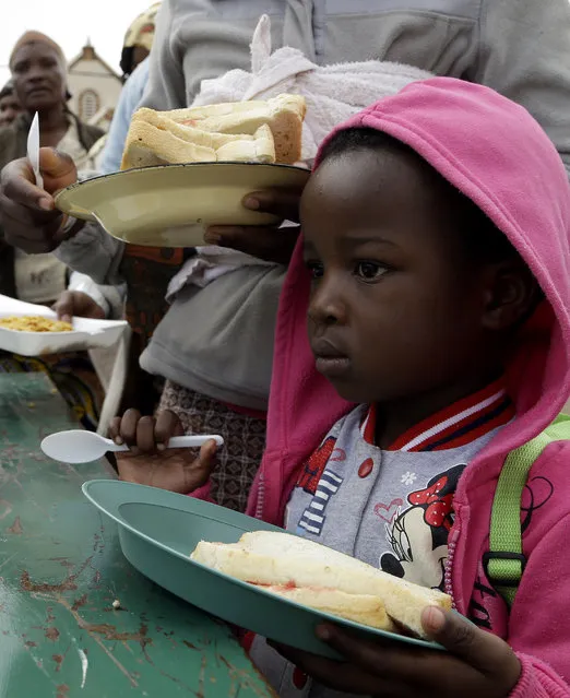 A child queues for food at a temporary refugee camp for foreign nationals, east of Johannesburg, South Africa, Monday, April 20, 2015. A total of seven people have died in attacks on immigrants in South Africa in the past week bringing the South African president to postpone a key ceremony, his office said Monday. (Photo by Themba Hadebe/AP Photo)