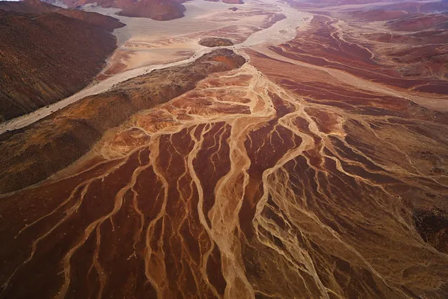 An aerial view of mountains and dry creek beds near Messum Crater, in October, 2014, in the Namib Desert, Namibia. (Photo by Theo Allofs/Barcroft Media)