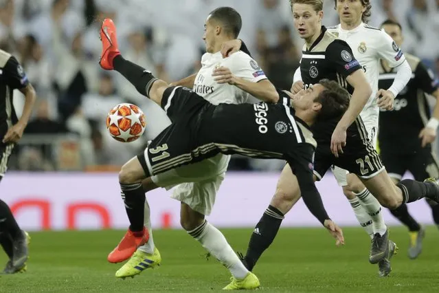 Real forward Lucas Vazquez, background, and Ajax's Nicolas Tagliafico challenge for the ball during the Champions League soccer match between Real Madrid and Ajax at the Santiago Bernabeu stadium in Madrid, Spain, Tuesday, March 5, 2019. (Photo by Manu Fernandez/AP Photo)